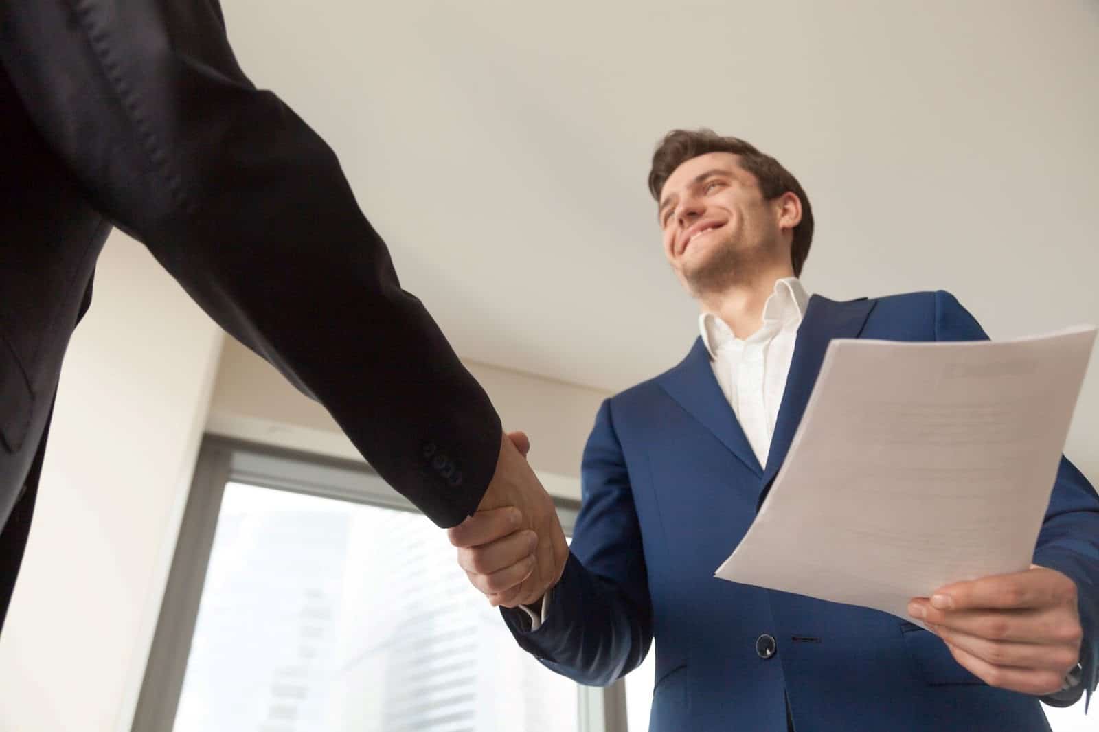 Candidate shaking hands with a recruiter after a successful job interview.